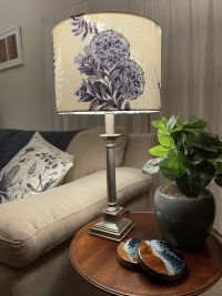 Medium drum light shade with blue kōwhai fabric on a silver table stand