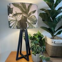 Tripod floor stand with green leaves on white fabric