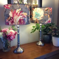 Brushed chrome table lamps with flowers on grey fabric